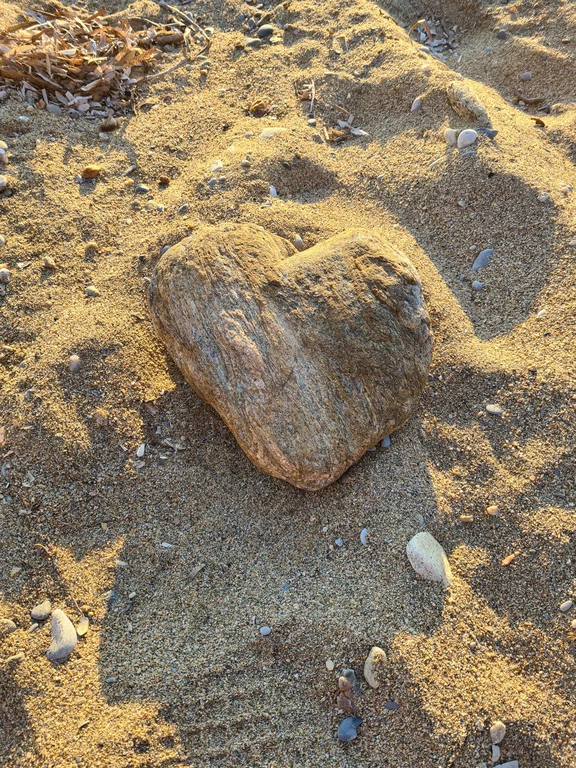 Herz in Steinform im Sand